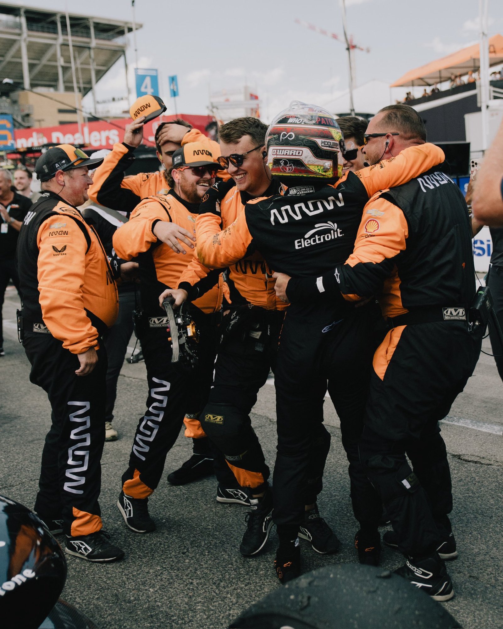 Chris Cousall celebrating with a motorsport team after a session.