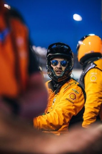 Chris Cousall in team gear during a night race setting.