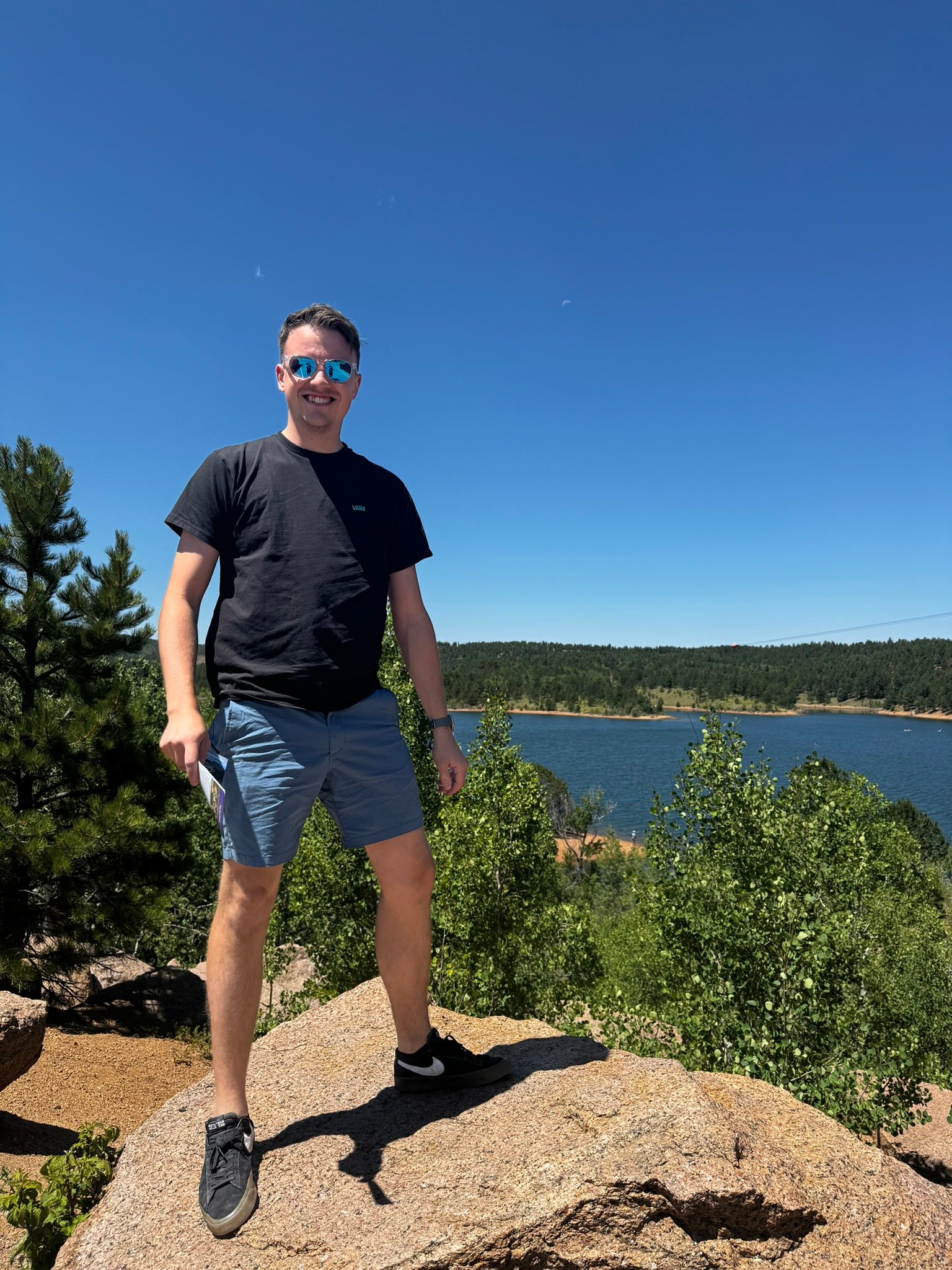 Chris Cousall standing on a rock above a lake.