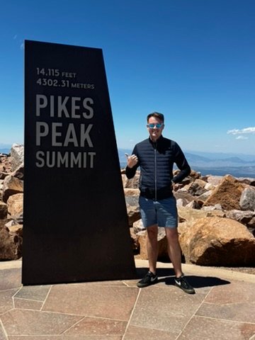Chris Cousall at the Pikes Peak summit sign.