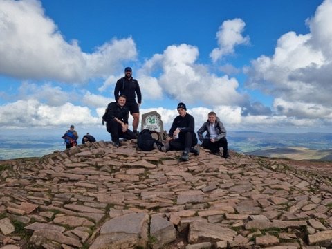 Chris Cousall with friends on a mountain summit.