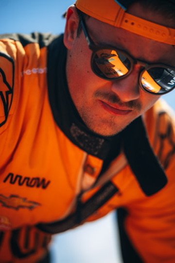 Chris Cousall in orange team gear in a close-up portrait.